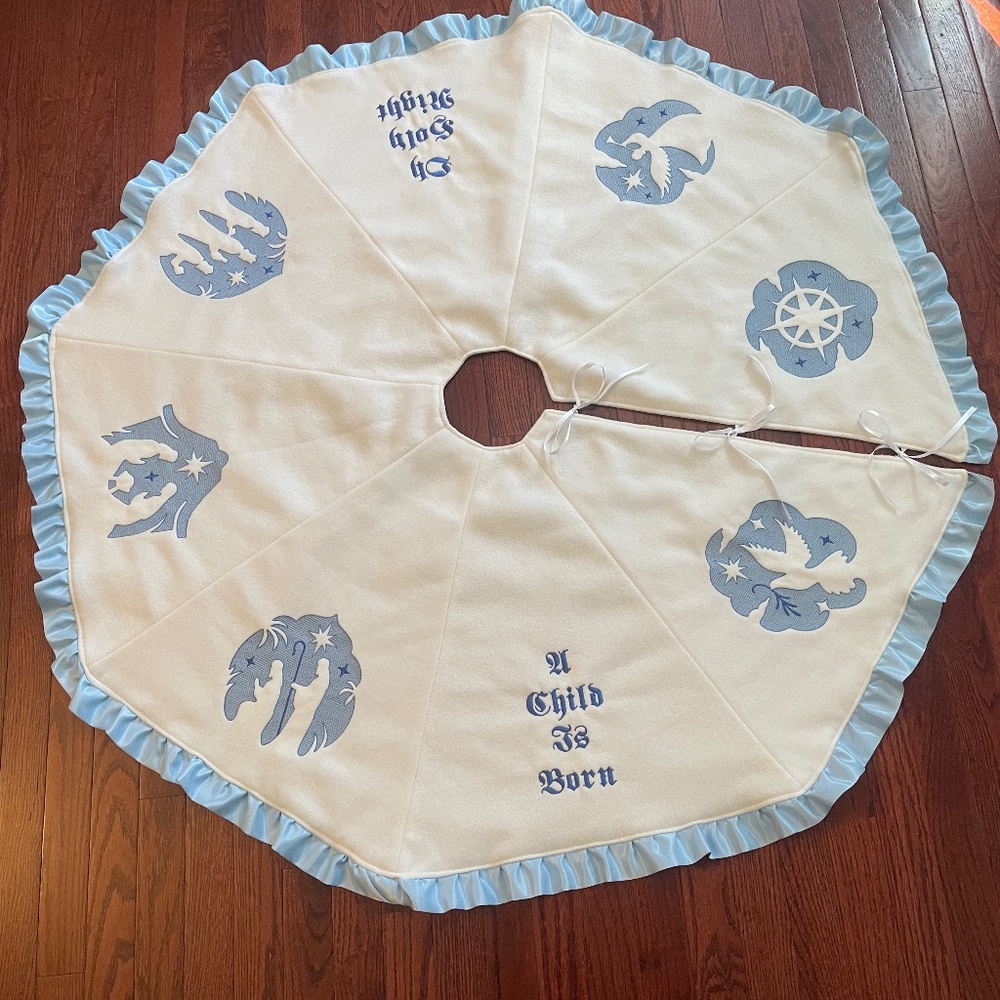 Christmas tree skirt, handcrafted, blue embroidery on cream fleece.